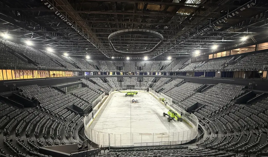 Pavilhão de hóquei no gelo vazio, com a pista já preparada e as bancadas por ocupar