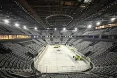 Pavilhão de hóquei no gelo vazio, com a pista já preparada e as bancadas por ocupar